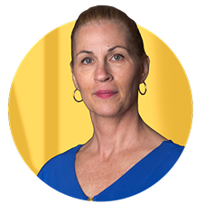 A woman looking into the camera wearing a blue shirt