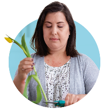 A woman cutting the stem of a flower